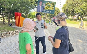 時事手舉牌力抗對手看板海 簡嘉佑：本人就在你面前