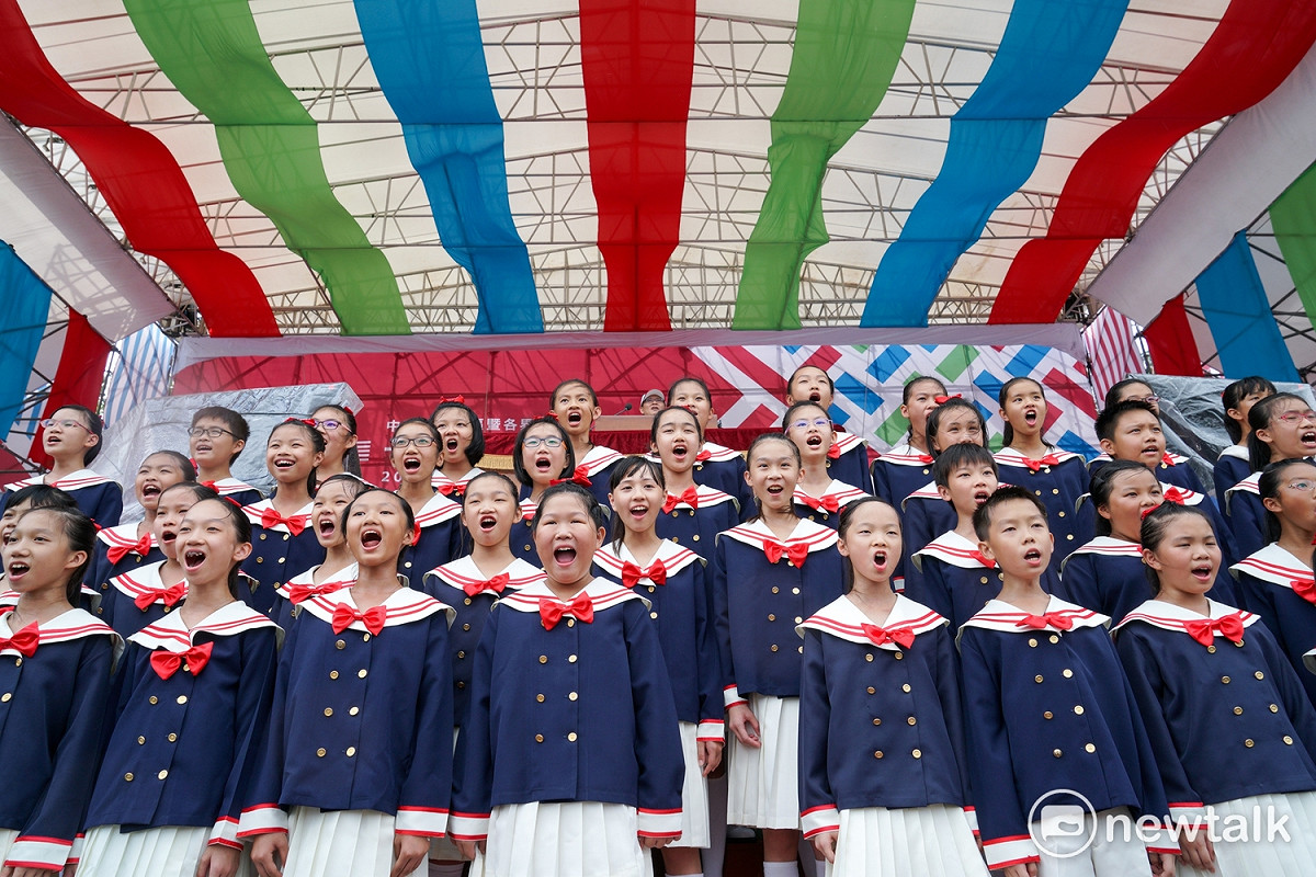 106年國慶預演，由甘惠忠神父帶領的南科實中國小部合唱團高唱國歌。 圖：張良一/攝