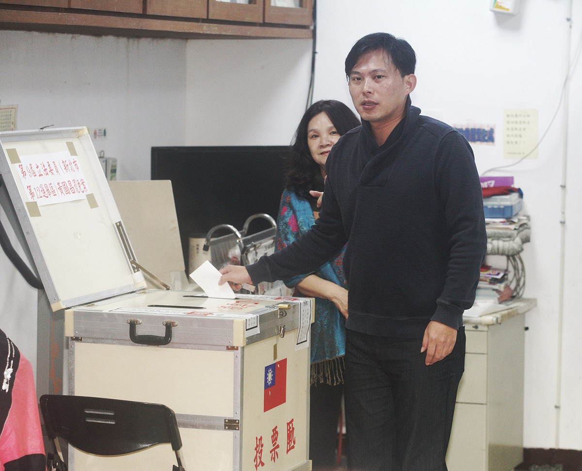 台灣民主政治頭一遭的黃國昌罷免案今舉行，由於氣溫驟降又下雨，投票並不踴躍，圖為被罷免人黃國昌在投票所投票。 圖：張良一/攝