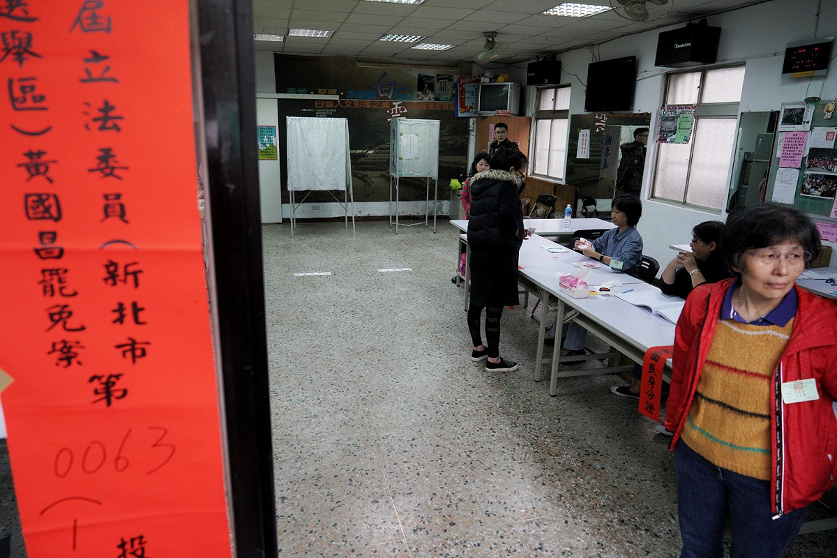 台灣民主政治頭一遭的黃國昌罷免案今舉行，由於氣溫驟降又下雨，投票並不踴躍，圖為選務人員在投票所內等選民來投票。 圖：張良一/攝