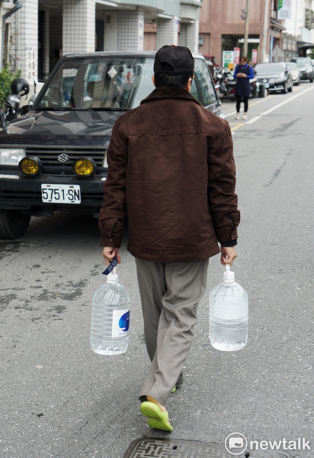 地震過後，許多地區仍未供水，一位無水可用的民眾自行提水回家。 圖：張良一/攝