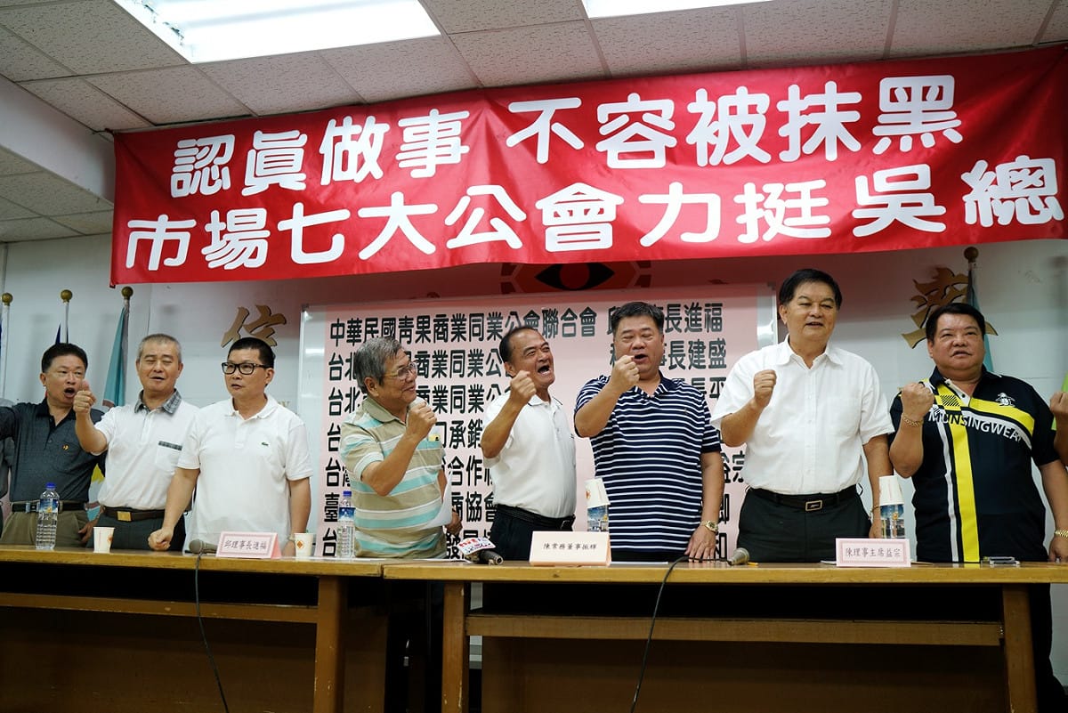 中華民國青果商業同業公會理事長邱進福等七大青果蔬菜公會在北農第一果菜拍賣市場舉行記者會，聲援北農總經理吳音寧，眾人並一起呼喊加油！加油！口號向吳音寧打氣。 圖：張良一 / 攝