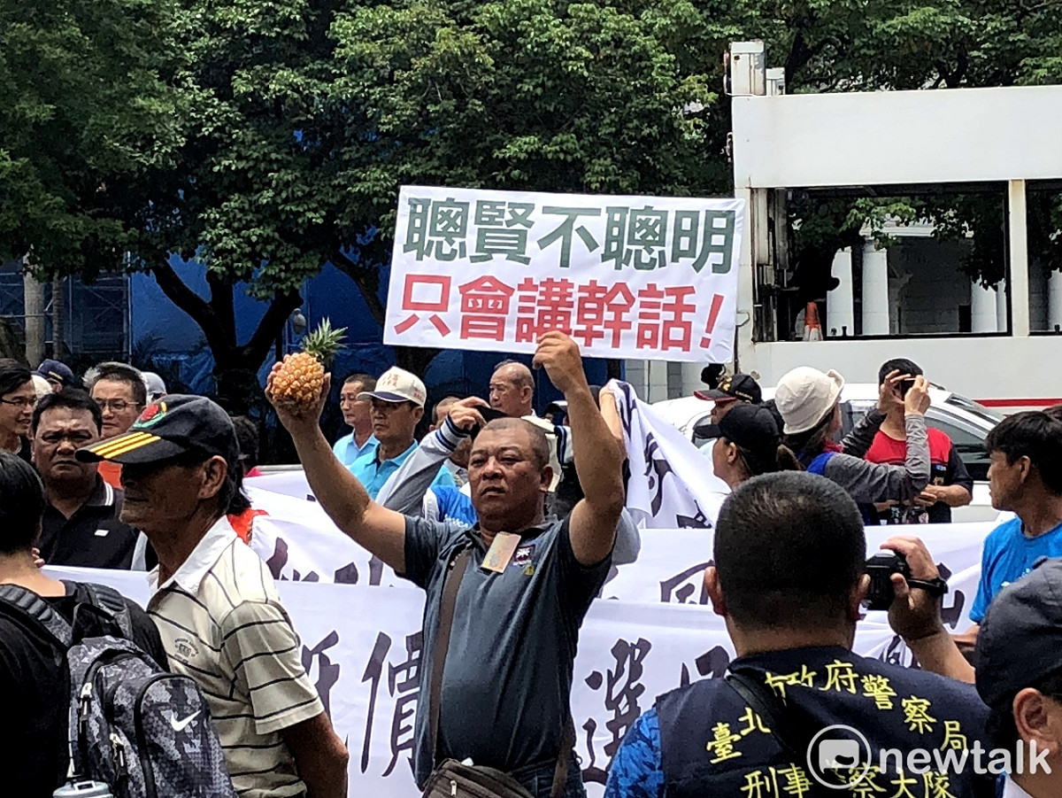 陳抗鳳梨農在行政院門口高喊：右手拿旺梨，左手比下台！ 圖：張元誠、聶良恩/ 攝