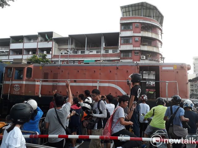 高雄臨港線從前鎮車場開出最後一班車，百年歷史的臨港線鐵路正式走入歷史，許多鐵道迷不捨，今齊集在各平交道，拍攝最後一班列車身影。 圖：金名/攝