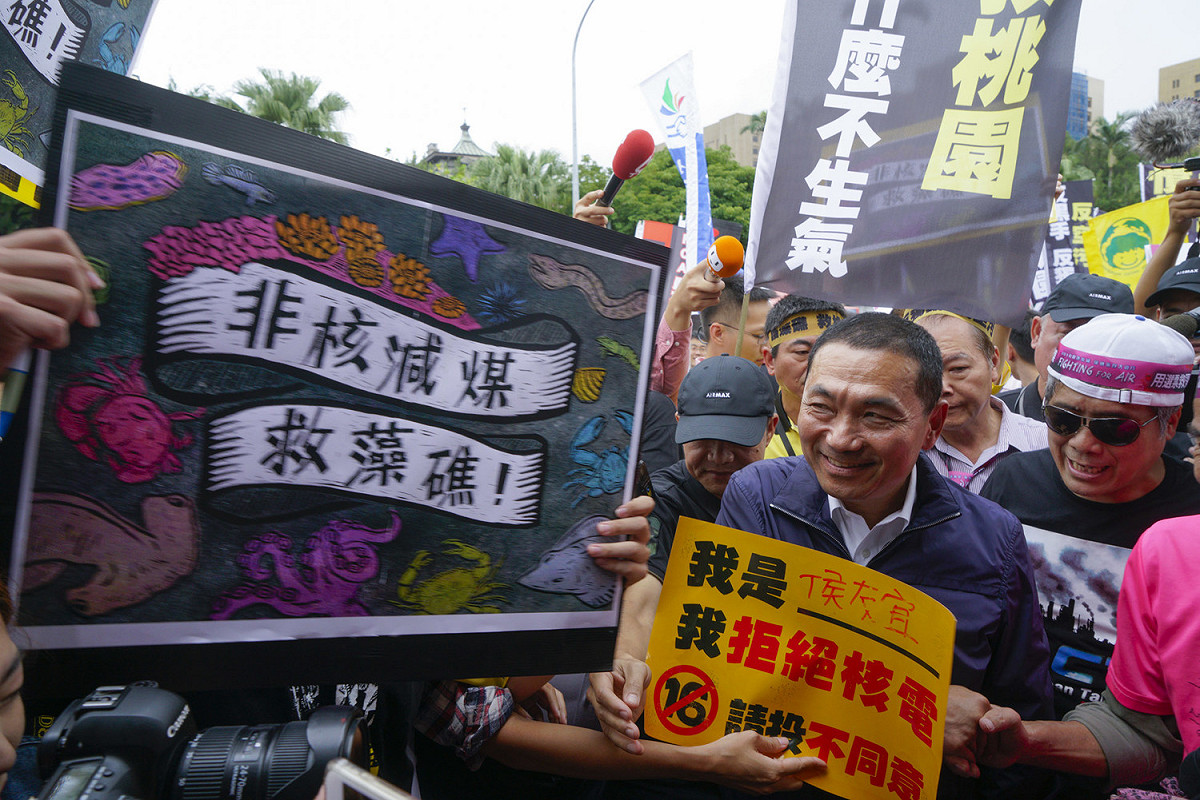 國民黨新北市長參選人侯友宜也參與反空污遊行，卻一路被拿著「非核減媒救藻礁」的年輕人嗆聲。 圖：張良一/攝