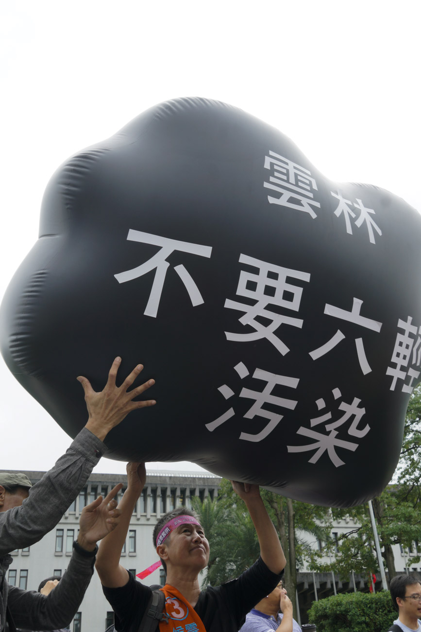雲林縣長參選人王麗萍頭頂空污污雲造型參與遊行。 圖：張良一/攝