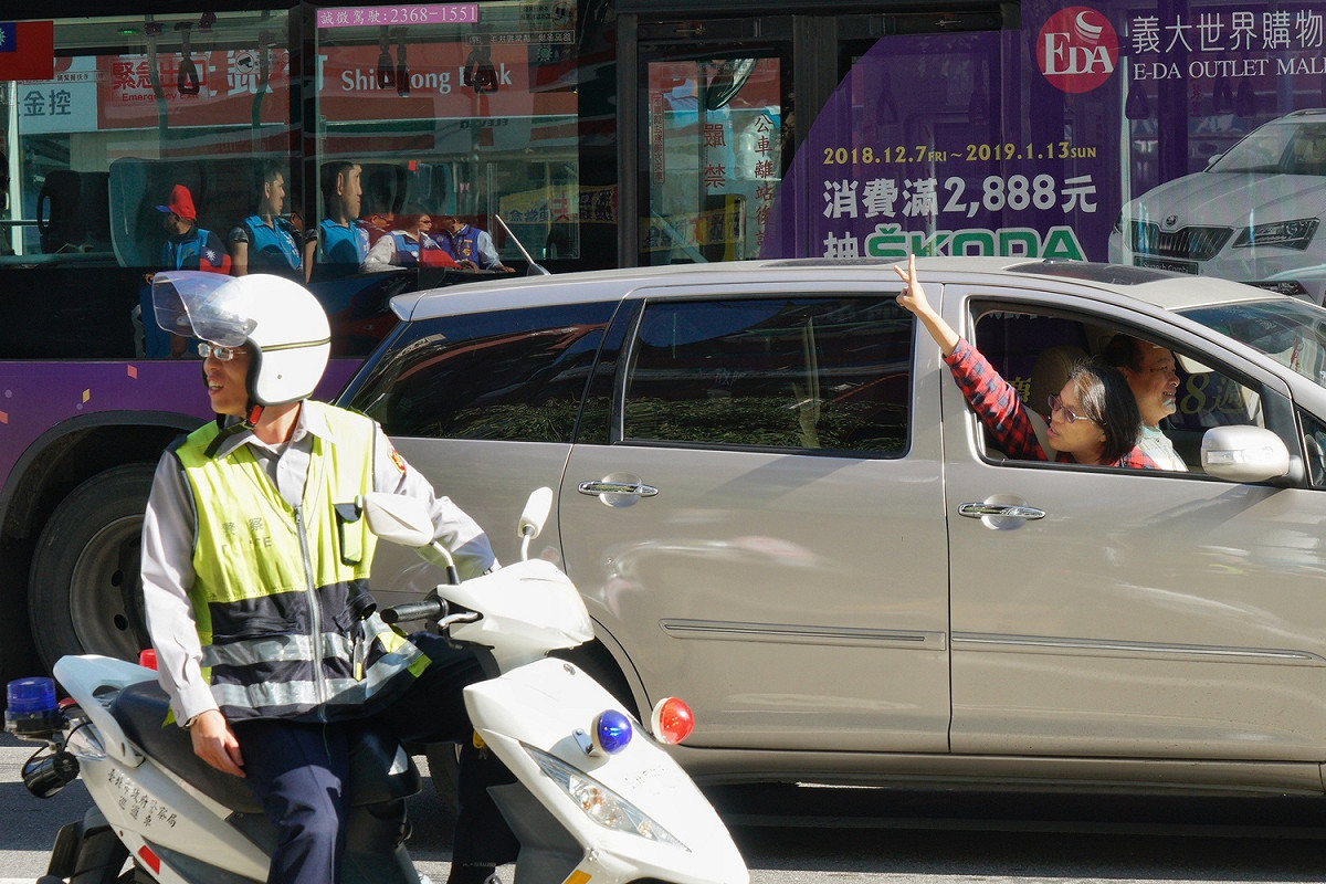 國民黨台北市長候選人丁守中上午在中正、萬華區掃街時，時，一位支持者搖下車窗向丁比出二號手勢。 圖：張良一/攝