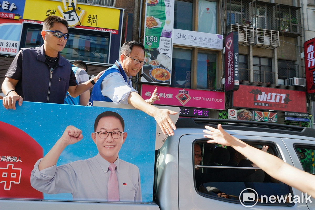 國民黨台北市長候選人丁守中上午在中正、萬華區掃街時，一位支持者跑向前和丁握手。 圖：張良一/攝