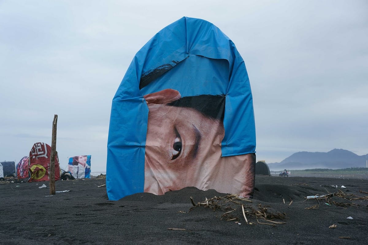圖為「圖文特寫」第三名作品：在宜蘭蘭陽溪出海口捕鰻魚苗的漁人將候選人的競選帆布改裝成遮風避雨的小屋。 圖：張良一/攝