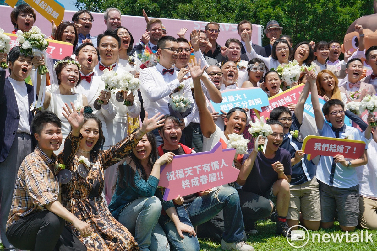 20對同性伴侶在台北市信義區戶政事務所完成結婚登記後，開心地在信義行政中心外合影。 圖：張良一/攝
