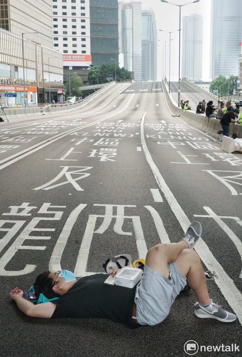 一位香港青年在政府總部前躺下，在已經封閉的夏慤道上休息。 圖：張良一/攝