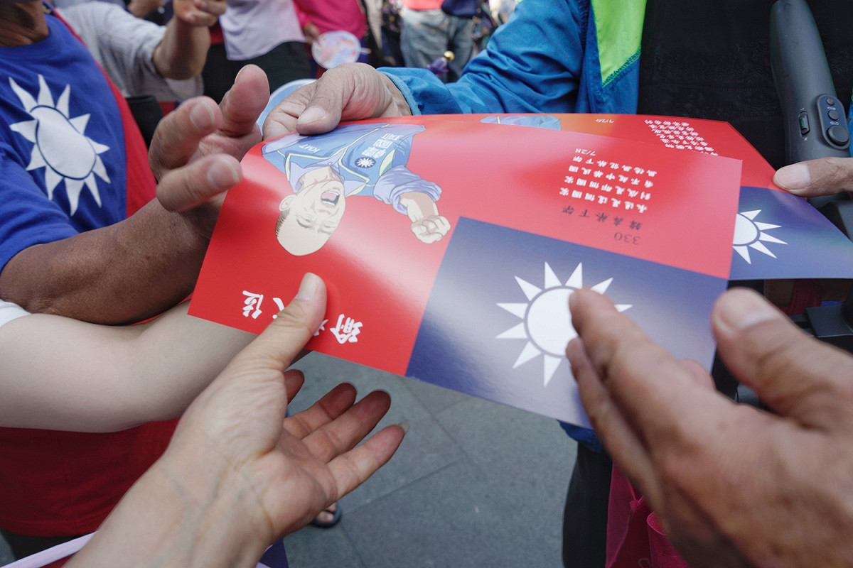 國民黨總統參選人韓國瑜到彰化地區參拜多個鄉鎮的宮廟，希望能挽救直往下墜的民調，韓國瑜上午十時來到首站的鹿港天后宮，數百位堅定韓粉在天后宮外守候等待韓國瑜的到來。圖為韓粉爭相拿取韓國瑜貼紙。 圖：張良一/攝