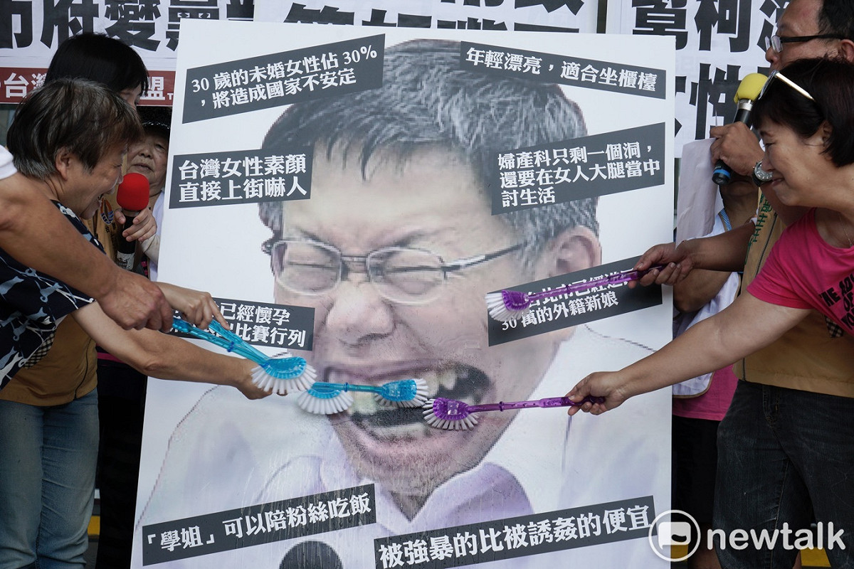 台灣團結聯盟成員在台北市政府前舉行的「請柯文哲管好市政、管好嘴巴」記者會中，用刷子刷柯文哲圖像中牙齒，藉此抗議柯文哲物化女性的諸多言論。 圖：張良一 / 攝