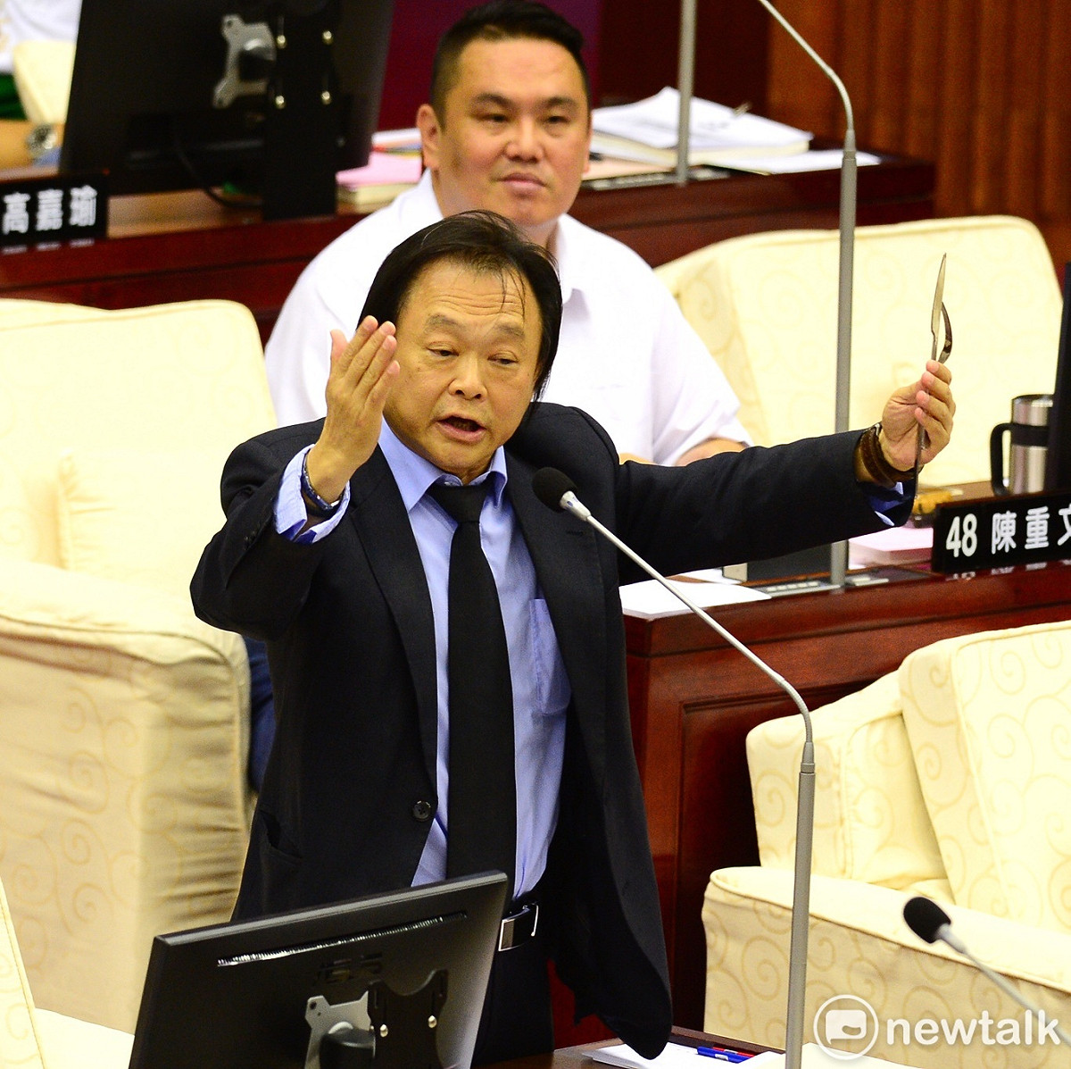 民進黨台北市議員王世堅在議場拿出刀叉，指台北市長拿刀叉吃人肉，吃人夠夠。 圖：張良一/攝