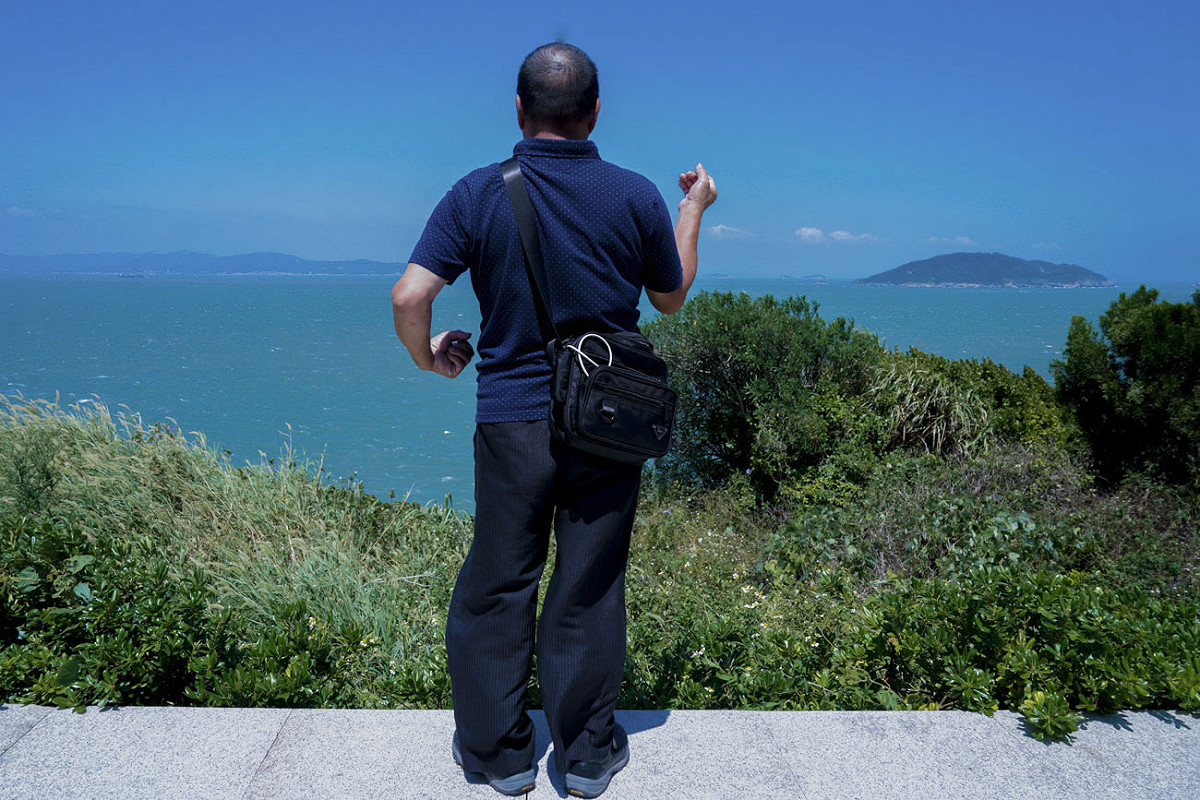 今年63歲，陸軍1096梯次的黃進山，沒想到睽違40年後，她還能回到昔日當兵的海防班哨。他很想再看看當年他在哨所旁種的樹苗，無奈漫草遮擋了去路。 圖：張良一/攝