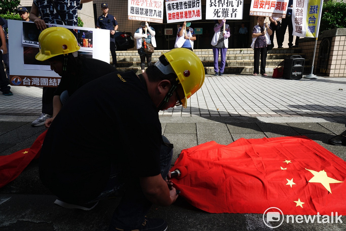 針對香港反送中抗議，有多位被逮捕的年輕人傳出被港警性侵、性暴力對待，台聯成員下午在移民署舉行記者會，要求移民署禁止港警、公安、武警身份者入境台灣，台聯成員並在會中焚燒中國五星旗抗議。 圖：張良一/攝