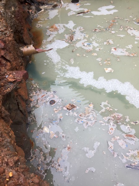 現場水坑中殘留不明綠色液體，經環保局採集場內外水質判定呈強酸性且有明顯重金屬反應 圖：新北市環保局/提供
