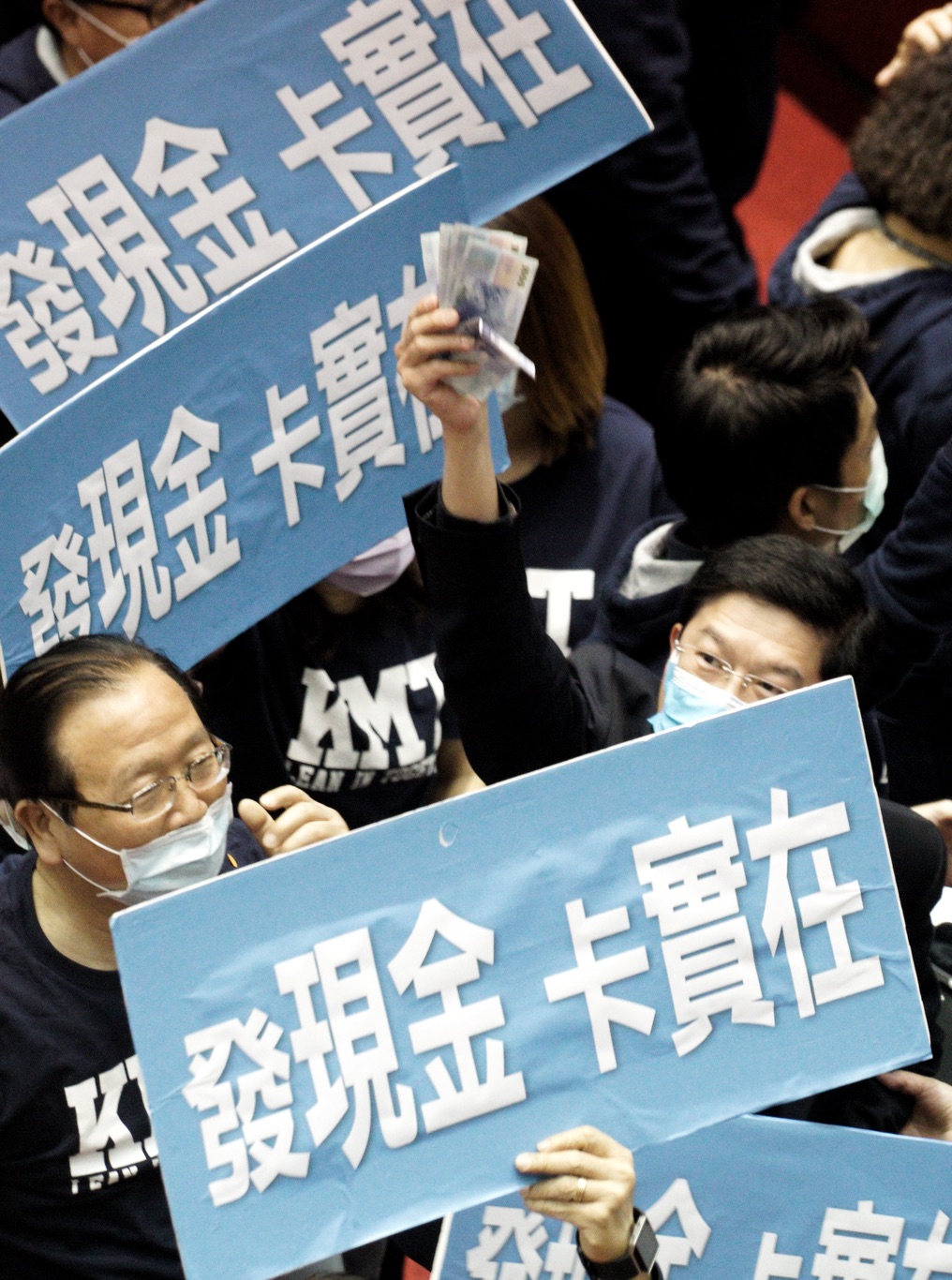 立法院院會審查「嚴重特殊傳染性肺炎防治及紓困振興特別條例部分條文修正草案」，國民黨立委在表決時高喊「發現金卡實在」口號，立委羅明才更高舉千元大鈔附合。 圖：張良一/攝
