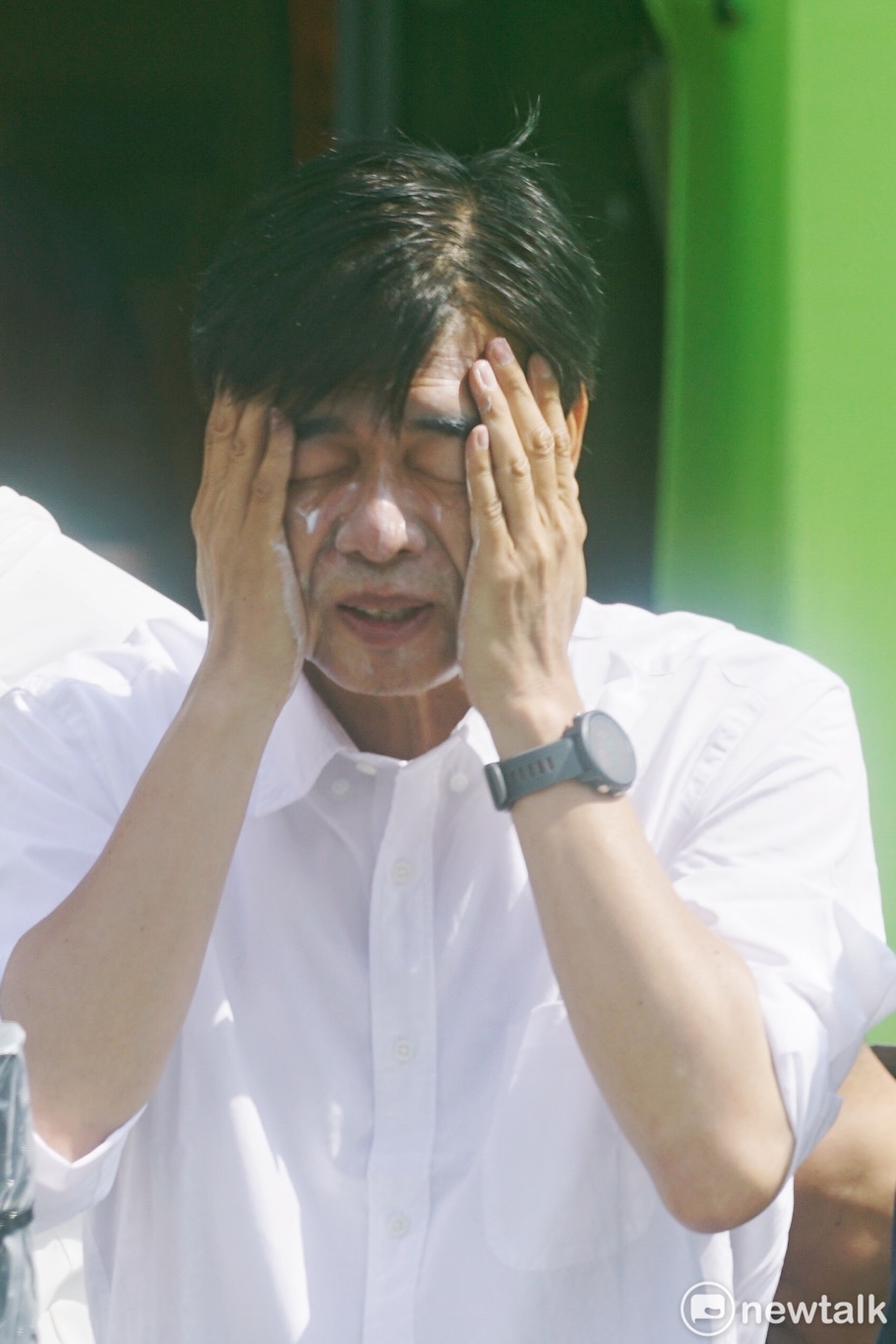 高雄市長當選人陳其邁上午在左營、楠梓、鼓山、鹽埕等地，向選民謝票。圖為陳其邁掃街前在臉上塗抹防曬乳液。 圖：張良一/攝