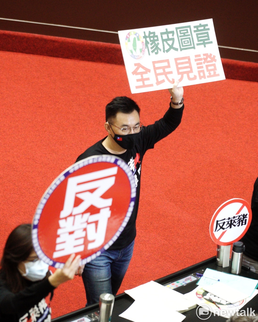立法院院會今進行萊豬表決大戰，國民黨立委江啟臣在表決時高舉「民進黨橡皮圖章全民見證」手舉牌。 圖：張良一/攝