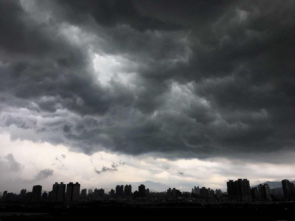 台北上空下午烏雲密佈雷聲大作，部份地區也下起大雨。 圖：張良一/攝