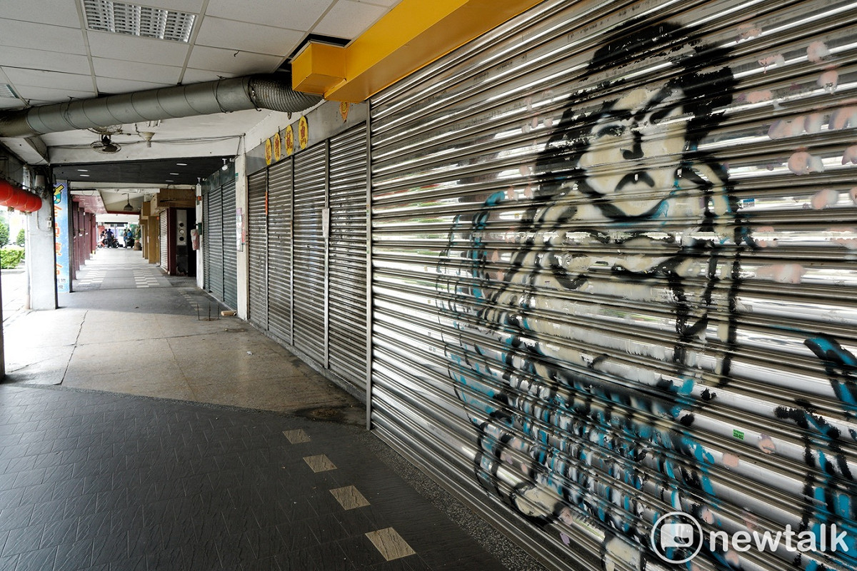 疫情延燒，不少店家受到衝擊。圖為店家拉下鐵門停止營業。 圖：張良一/攝