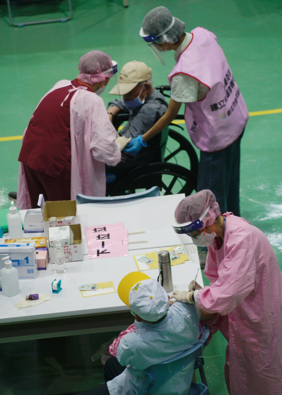 疫情指揮中心下週三（14）將召開會議，研擬長照、日照中心的放寬程序。（圖為年長者在大型接種站施打疫苗） 圖：張良一/攝
