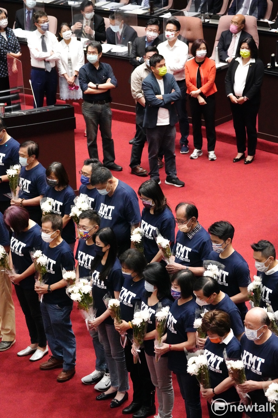 國民黨立委在立法院議場內，手持白花為武漢肺炎過世國人默哀一分鐘。 圖：張良一/攝
