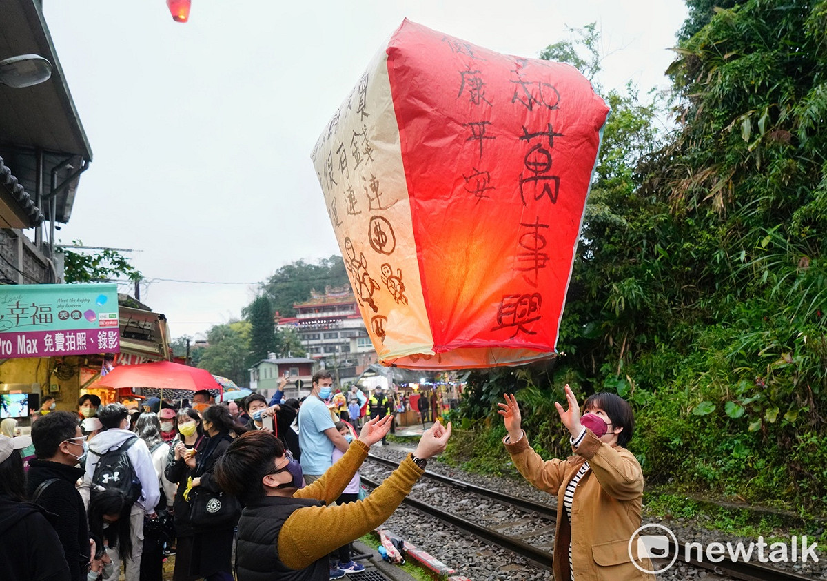 一些民眾不等天黑就在平溪火車站旁，點燃象徵希望的天燈。 圖：張良一/攝