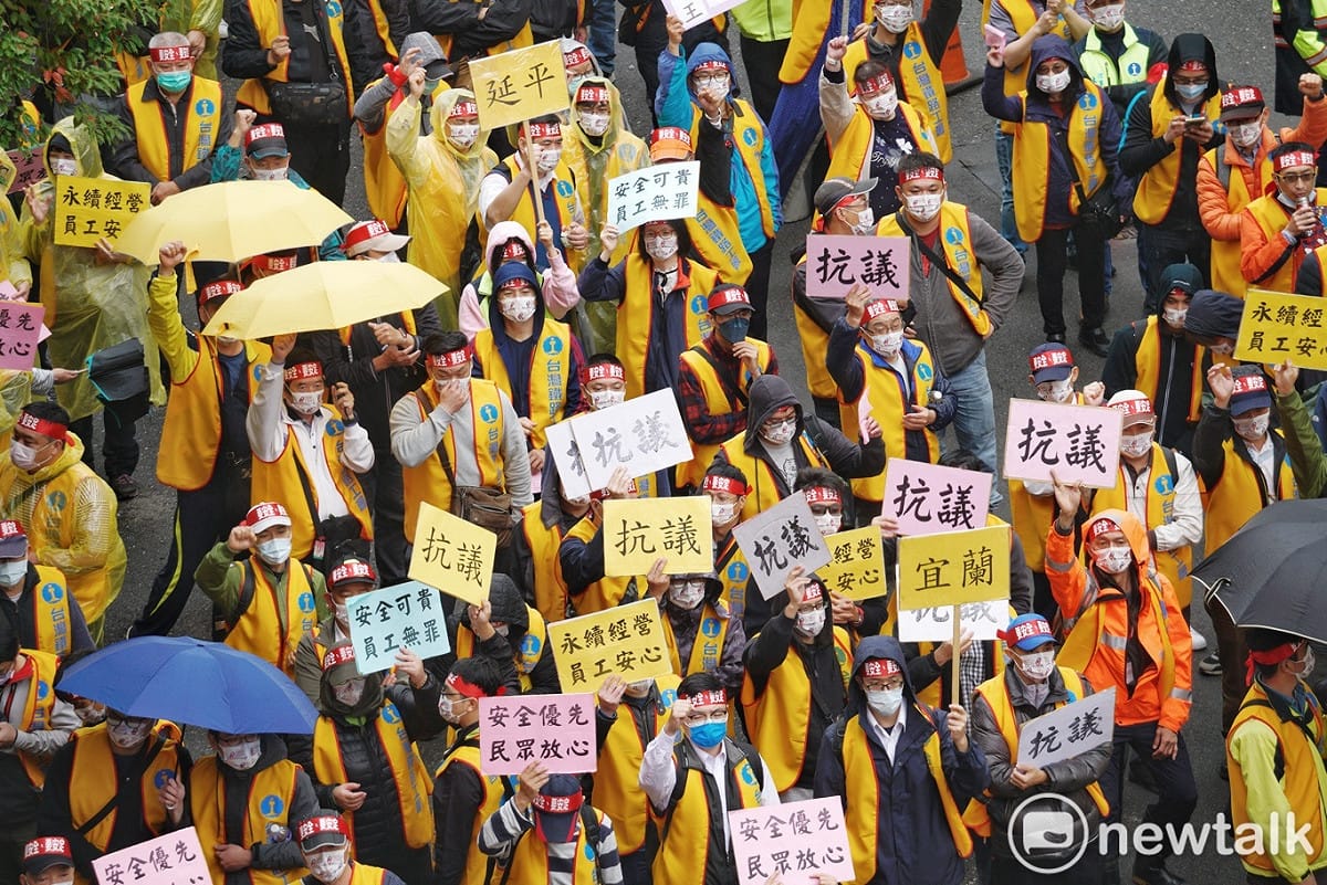 數百位台鐵工會員工上午冒雨在立院群賢樓外舉牌抗議。 圖：張良一/攝