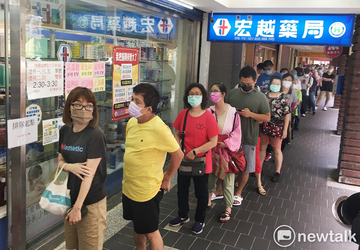 快篩實名制上路，許多民眾在一家健保藥局外大排長龍等候購買快篩試劑。 圖：張良一/攝（資料照）