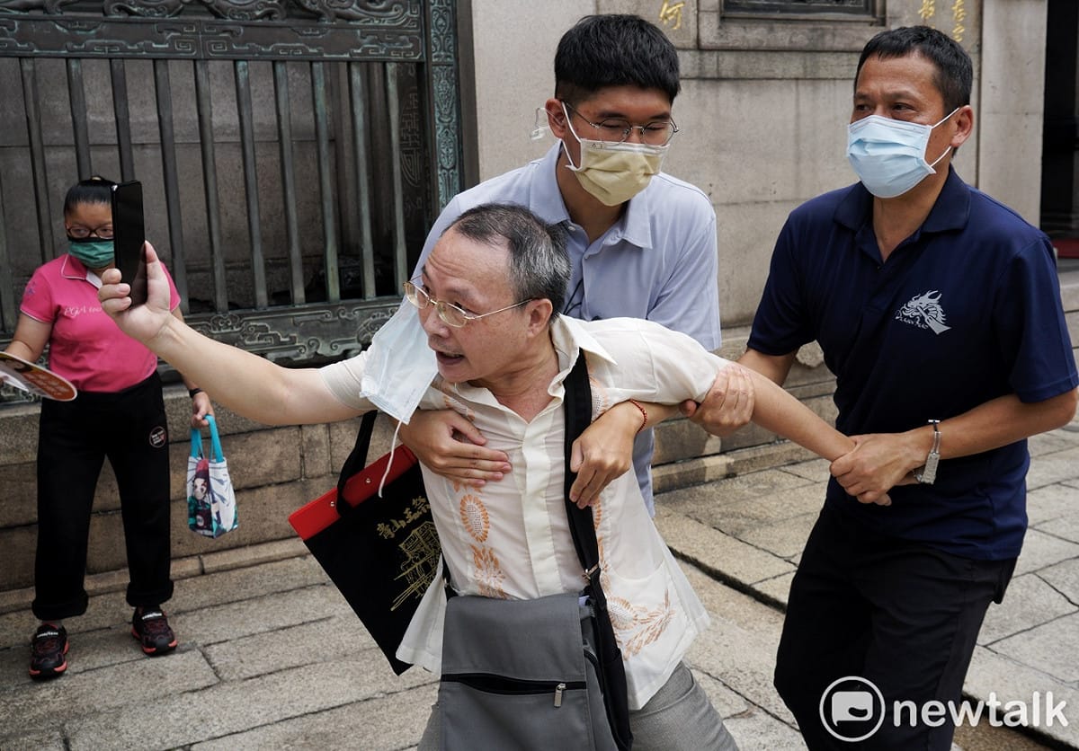 民進黨提名台北市長參選人陳時中到艋舺龍山寺參香時，有市民趁機向他陳情，但被工作人員架開。 圖：張良一/攝（資料照）
