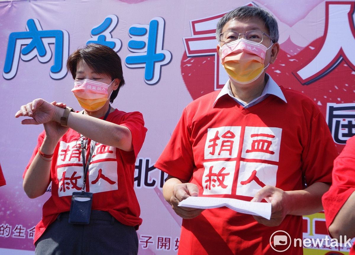 台北市副市長黃珊珊在內科千人捐血活動中看了她的手錶。隨著登記參選市長的日期接近，黃珊珊也將辭官參選台北市長。右為台北市長柯文哲。 圖：張良一 / 攝