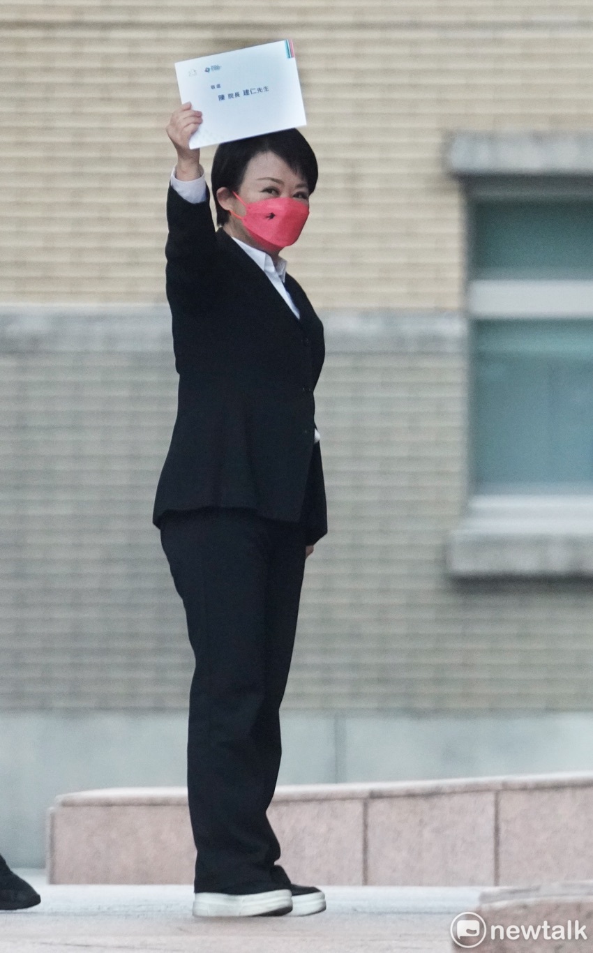 台中市長盧秀燕列席行政院院會前，高舉邀請行政院長陳建仁出席世界棒球經典賽的邀請函給媒體拍照。 圖：張良一/攝
