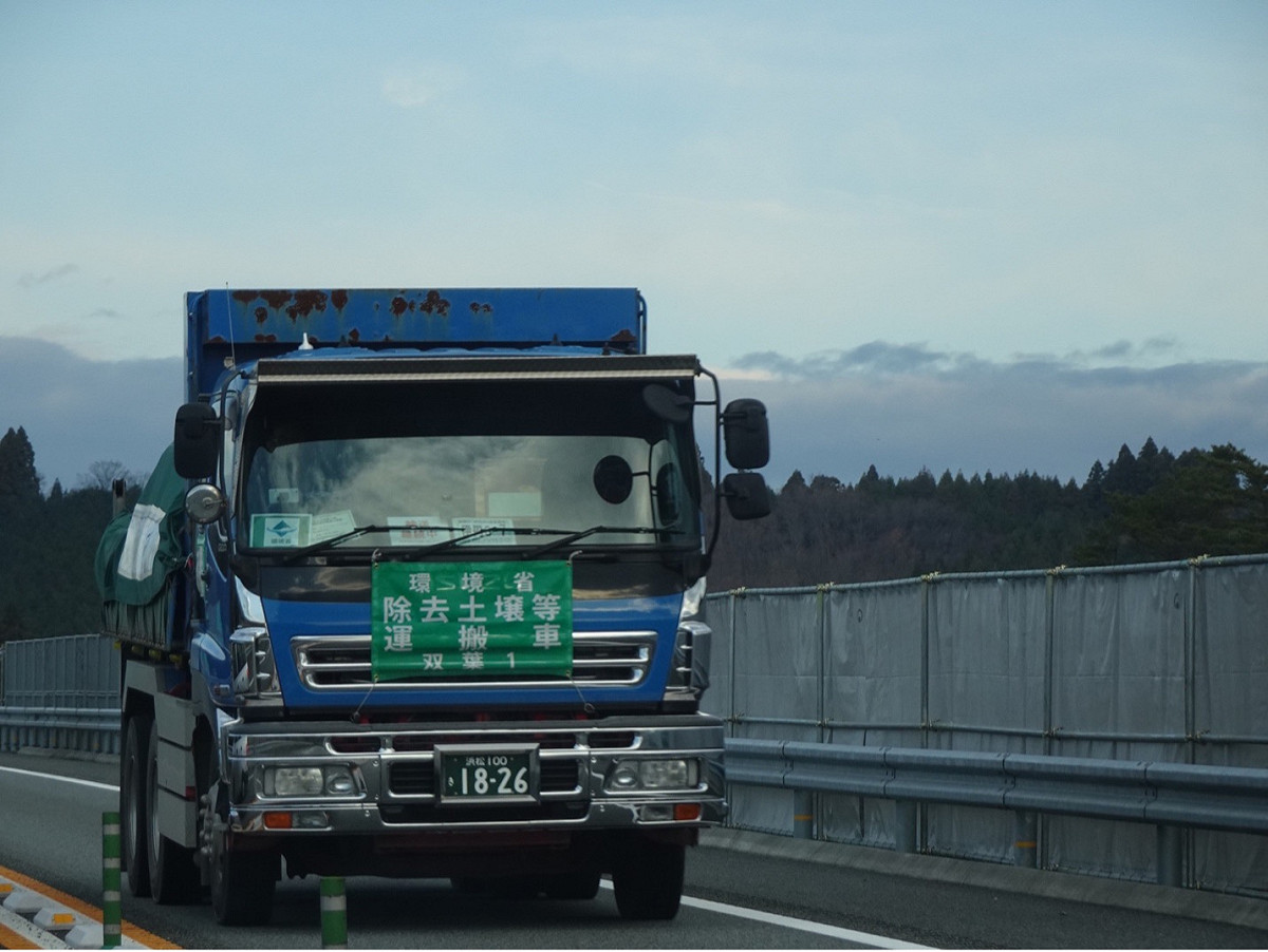 每天成千上萬輛環境省的「除去土壤等運搬車」在福島週邊把核災污染廢土搬來搬去，有了車輪的「福」，就成了「輻」，而且還要再把除污後的土壤分到福島以外的縣市享「輻」。 圖：方儉／攝