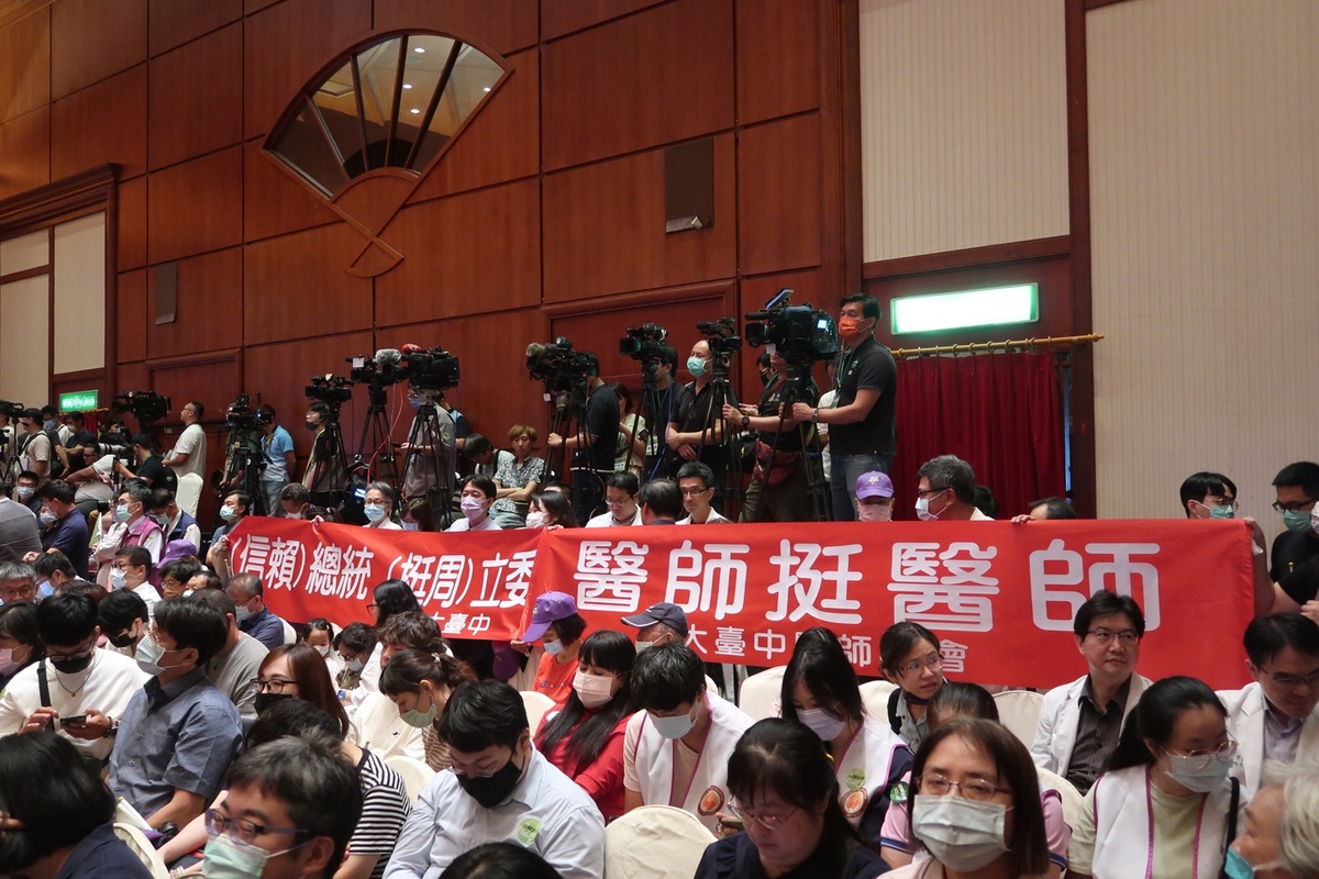 支持中華民國醫師公會全國聯合會理事長周慶明的大台中醫師公會還在座位後方拉起一條「信賴總統、挺（周）立委，醫師挺醫師」紅色布條，支持他列入民進黨不分區立委。 圖：林朝億/攝
