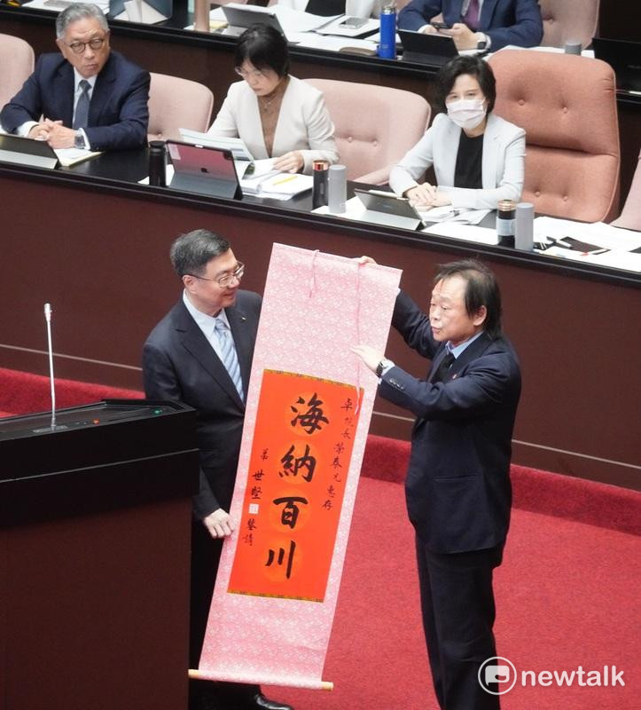 民進黨籍立委王世堅上午在立院總質詢時，贈送一幅書寫「海納百川」的中堂送給行政院長卓榮泰，但卓院長沒接到，掉到地上。 圖：張良一/攝