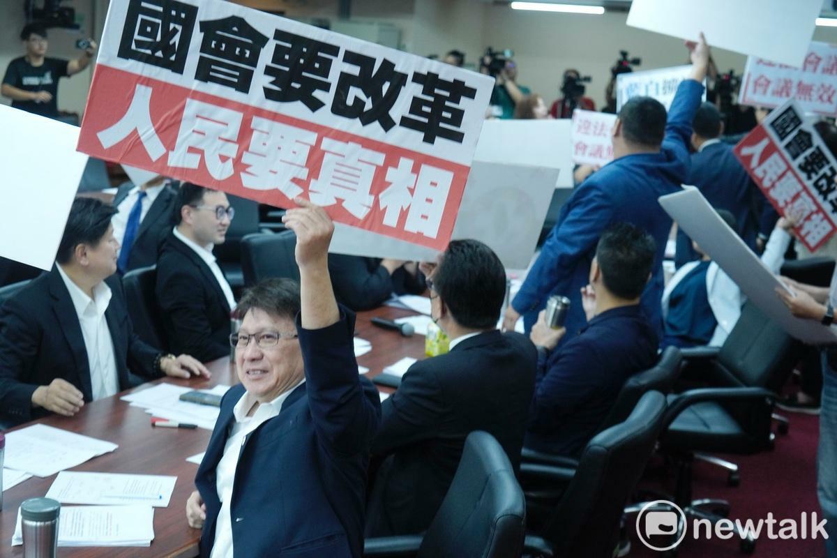 立法院交通及司法法制委員會聯席會今欲成立「鏡電視調查專案小組」，但民進黨立委以聯席會未經院會通過，屬於違法會議，藍綠立委因而陷入冗長的議事詢問。最後，民進黨高舉「違法會議 會議無效」等手舉牌並集體退席抗議，而藍白委員則高舉「國會要改革 人員要真相」手舉牌回應。 圖：張良一/攝