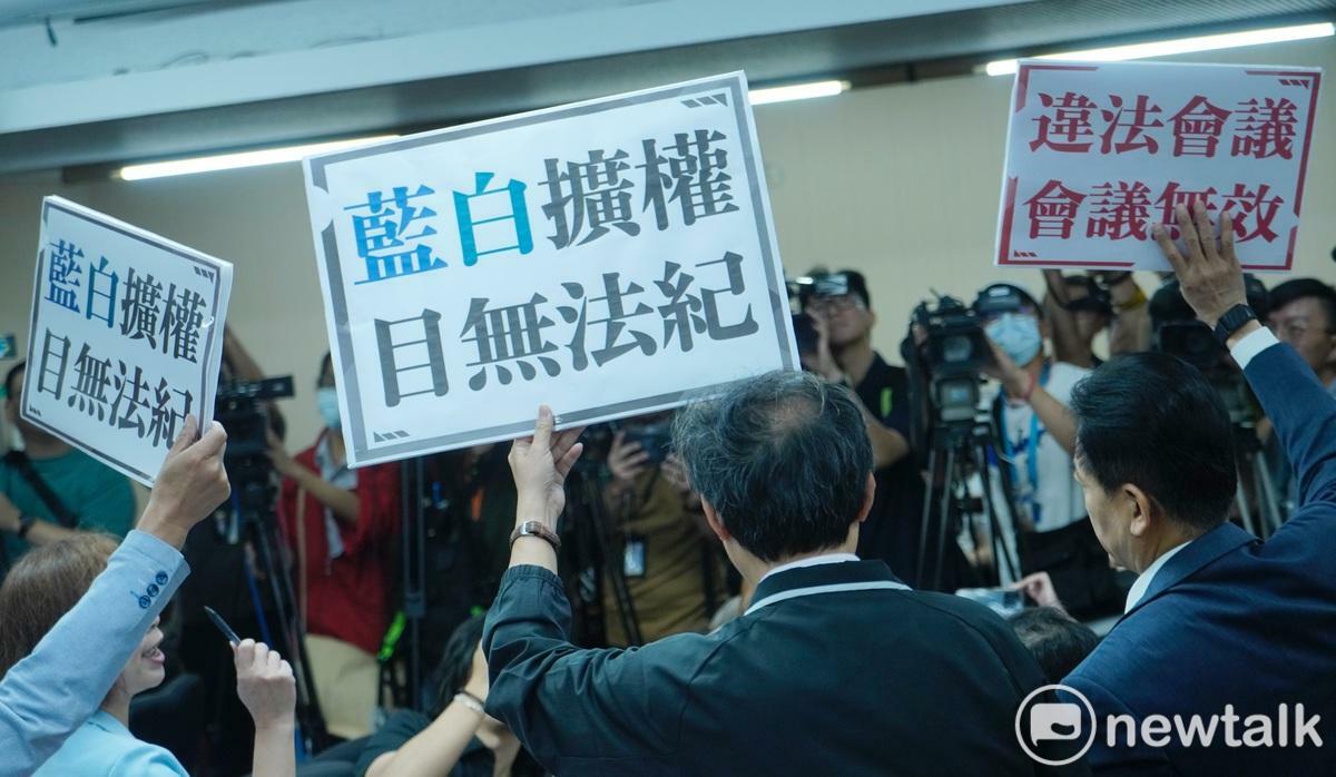 民進黨立委手舉違法會議抗議藍白通過鏡電視調查小組。 圖：張良一/攝