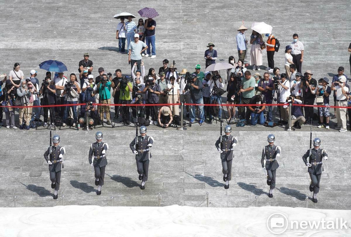 今天是三軍儀隊撤出中正紀念堂銅像大廳，改移至民主大道進行每整點訓練展示首日，上午九點第一場演出仍吸引許多觀光客駐足觀看，雖然天氣相當炎熱，但中正紀念堂志工轉述儀隊隊員說，只要演出15分鐘就好，不用站哨一小時，勤務輕鬆許多。 圖：張良一/攝