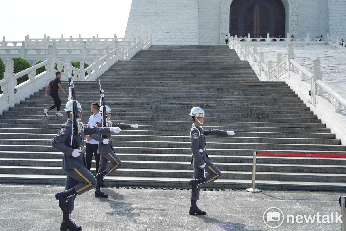 今天是三軍儀隊撤出中正紀念堂銅像大廳，改移至民主大道進行每整點訓練展示首日，上午九點第一場演出仍吸引許多觀光客駐足觀看，雖然天氣相當炎熱，但中正紀念堂志工轉述儀隊隊員說，只要演出15分鐘就好，不用站哨一小時，勤務輕鬆許多。 圖：張良一/攝