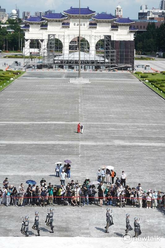 今天是三軍儀隊撤出中正紀念堂銅像大廳，改移至民主大道進行每整點訓練展示首日，上午九點第一場演出仍吸引許多觀光客駐足觀看，雖然天氣相當炎熱，但中正紀念堂志工轉述儀隊隊員說，只要演出15分鐘就好，不用站哨一小時，勤務輕鬆許多。 圖：張良一/攝