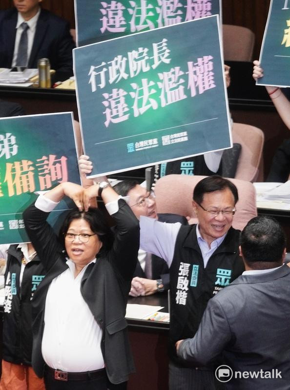 立法院新會期今開議，民眾黨立委在行政院長卓榮泰面前舉牌杯葛議事，民進黨立委王美惠則是手比愛心反制。 圖：張良一 / 攝