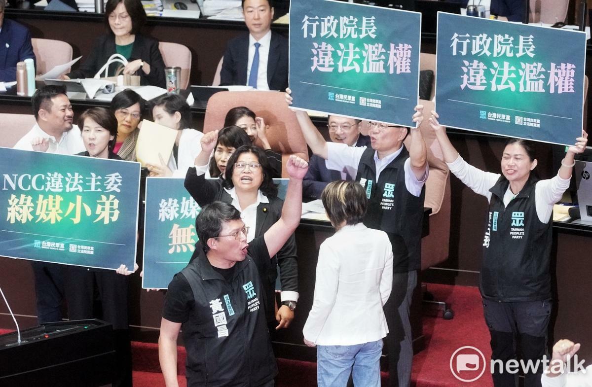 立法院新會期今開議，民眾黨立委在行政院長卓榮泰面前舉牌杯葛議事，民進黨立委王美惠則是手比愛心反制。 圖：張良一 / 攝