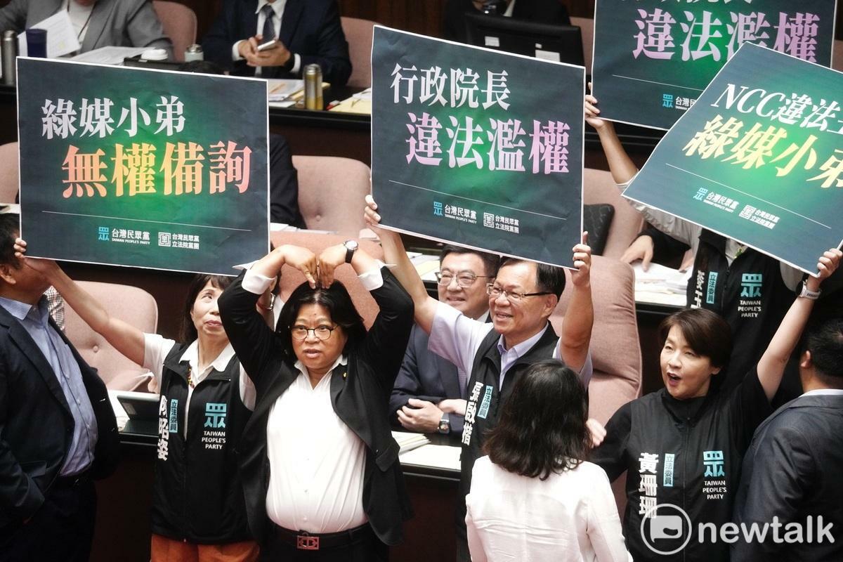立法院新會期今開議，民眾黨立委在行政院長卓榮泰面前舉牌杯葛議事，民進黨立委王美惠則是手比愛心反制。 圖：張良一/攝
