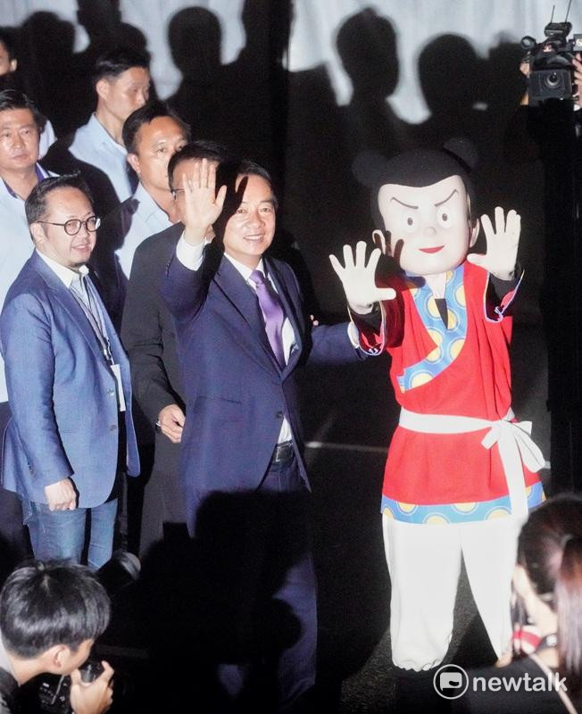 總統賴清德出席2024國慶總統府建築光雕展演「當我們同在一起」點燈儀式時，和諸葛四郎人偶一起向與會人士揮手。 圖：張良一/攝