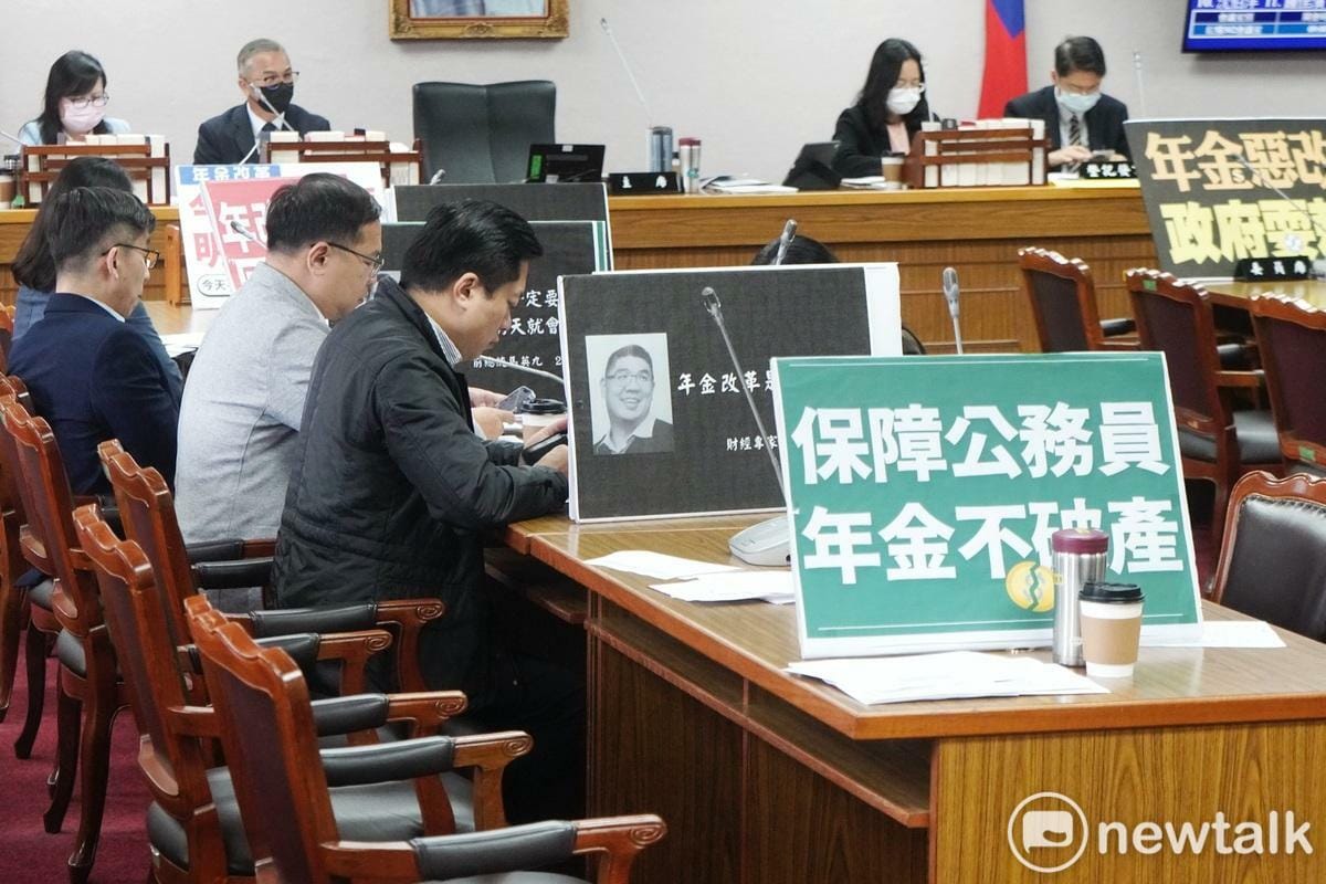 立法院司法及法制委員會今（5）天上午審查「公務人員退休資遣撫卹法」修正案，朝野立委將手舉牌放在委員席表達立場。 圖：張良一/攝