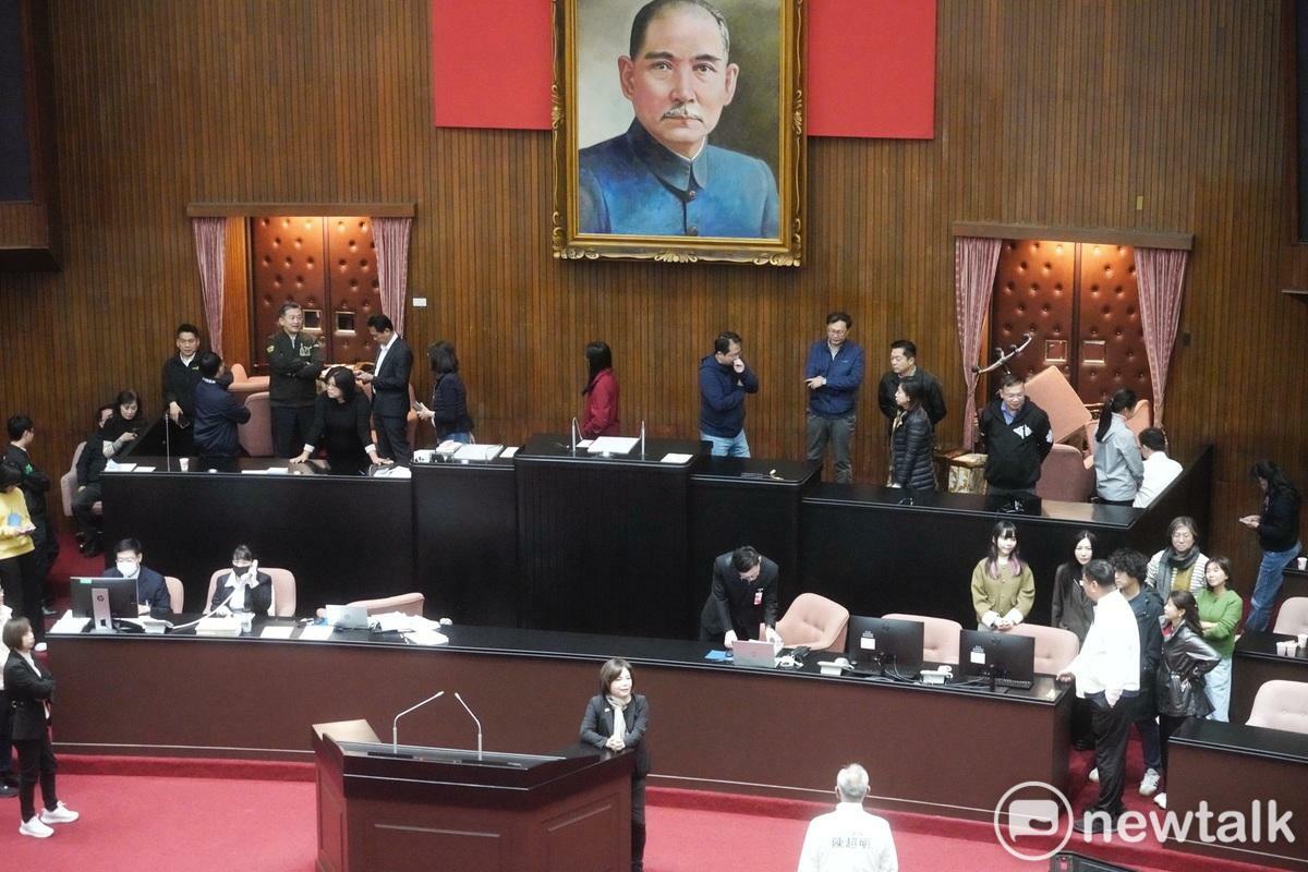 立院國民黨團今（13）日欲強行闖關選罷法修正草案，民進黨籍立委一早即佔據主席台，阻擾會議進行。圖為民進黨立委用主席和議事人員座椅圍堵出入口。 圖：張良一/攝