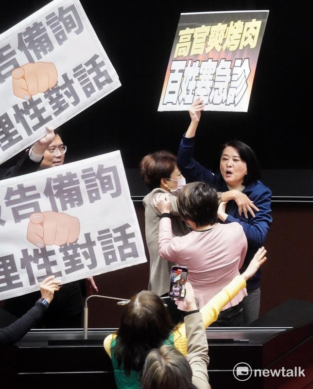 國民黨立院黨團書記長王鴻薇在議場舉牌意圖干擾行政院長卓榮泰的施政報告，而被民進黨立委勸離發言台。 圖：張良一/攝