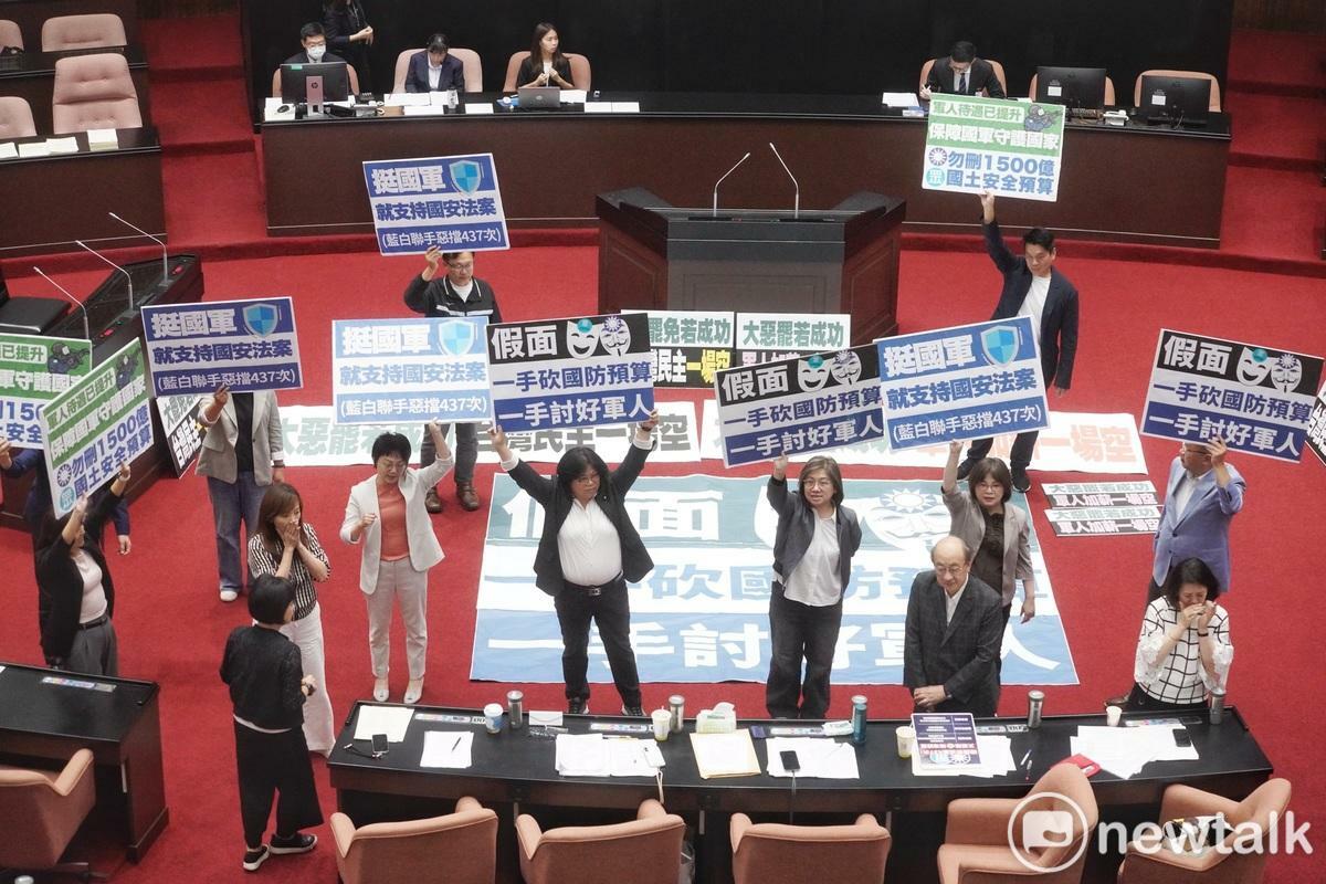 立法院會今（10）天審理軍人待遇條例第五條修正案，民進黨立委在表決前高舉「一手砍國防預算 一手討好軍人」反對此條修正案。 圖：張良一/攝